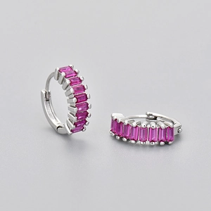Detailed macro view of silver hoop earrings with a row of rectangular pink crystals