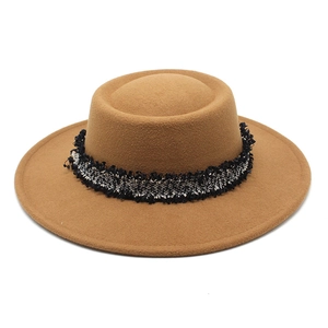 Detalle de sombrero de lana camel con cinta de tweed con flecos y ala ancha plana