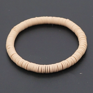 Detail macro-opname van beige polymeerklei heishi-kralen op een boho-armband