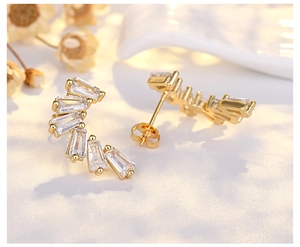 Close-up of elegant gold crescent moon stud earrings with sparkling zircon crystals