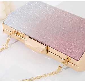 Detailed macro view of sparkling gradient glitter surface and gold metal frame on the clutch