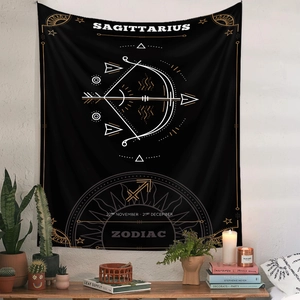 Detail of Sagittarius zodiac tapestry with gold sun motifs on white wall in boho room