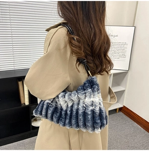 Detail of blue gradient plush shoulder bag featuring a unique knot handle design