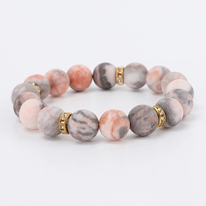 Detailed view of 8mm pink zebra jasper beads with gold rhinestone spacers on a bracelet