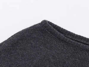 Détail de la robe en maille gris foncé montrant la couture du col et la texture du tissu