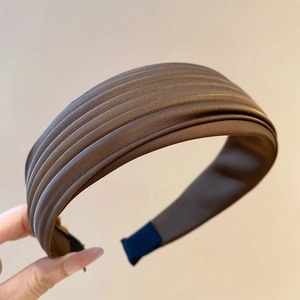 Détail d'un serre-tête en tissu plissé marron foncé avec doublure antidérapante