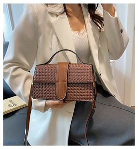 Detail of vintage woven texture shoulder bag in brown with smooth leather handles