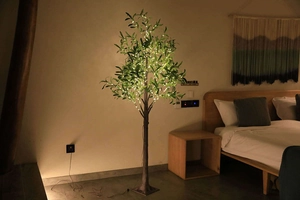 Close-up of LED olive tree branches with warm glowing lights and green leaves