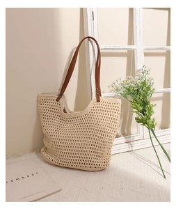 Detail of hollow-out woven cotton shoulder bag with brown leather straps and beige texture
