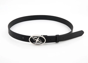 Detail of a thin black leather belt featuring a silver oval buckle with a star engraving