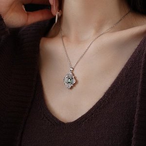 Close-up of model wearing emerald green geometric necklace with sparkling zircons