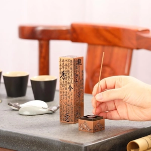 Macro detail of incense burner with Heart Sutra engraving and lotus pattern on copper