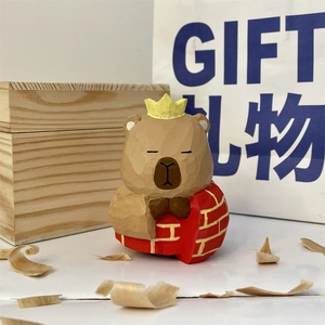 Detailed view of hand-carved wooden capybara figurine with crown and red shawl decor