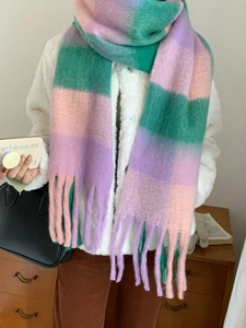 Detail of pink and purple rainbow plaid scarf with long fringes in warm winter style