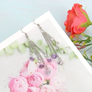 Detail of bohemian silver chain tassel earrings with purple natural crystal stones