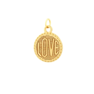 Detail of a round gold LOVE coin pendant with embossed lettering and textured edges