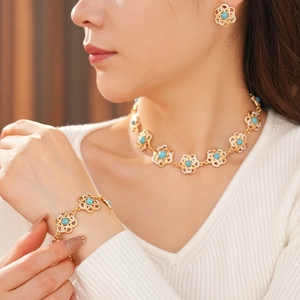 Detailed close-up of vintage gold hollow flower necklace with turquoise and diamonds