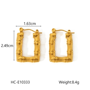 Détail de boucles d'oreilles dorées en U, dimensions 2,49 cm de hauteur et 1,63 cm de large
