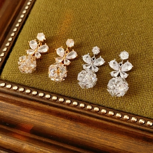 Vue détaillée de boucles d'oreilles papillon avec pierres précieuses sur velours vert