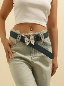 Detail of blue embossed leather belt featuring a large silver butterfly buckle on jeans