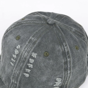 Macro view of distressed stitching and ripped details on a washed cotton baseball cap