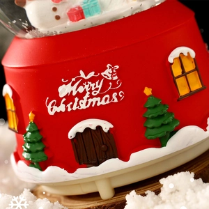 Red Christmas music box snow globe ornament with Merry Christmas text and resin winter scene