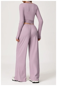 Rear view of mauve long-sleeve crop top with crossover ties and high-waist wide-leg pants