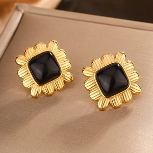 Macro detail of retro 18K gold plated square stud earrings with black resin center