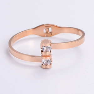 Macro shot of rose gold open bangle with cubic zirconia and Roman numerals engraving