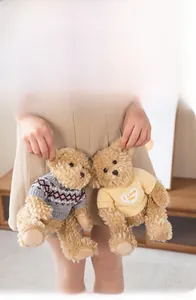 Detail of two teddy bears in grey and yellow sweaters with I Love You heart patches