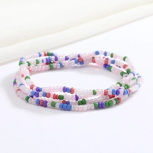 Detail of colorful layered seed bead chains featuring vibrant pink, blue, and green hues