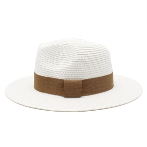 Detailed texture of a white Panama straw hat with a stylish brown ribbon band