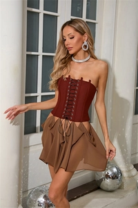 Détail du haut corset bordeaux à lacets et de la jupe courte asymétrique kaki ajustée