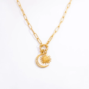 Macro detail of 18K gold sun and moon pendant necklace with white zircon inlays