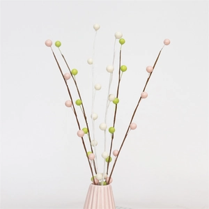 Detail of colorful artificial berry stems in a pink ceramic vase for spring decor