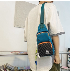 Side view of NANABAG blue sports chest bag with orange trim and mesh detail on male model