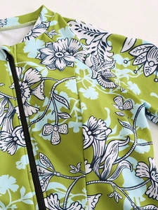 Close-up of grass green floral surfing swimsuit featuring a high neck and black zipper
