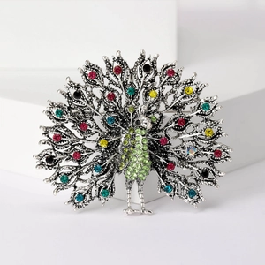Detail of peacock brooch featuring colorful rhinestones on a silver metal frame
