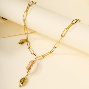 Bohemian gold chunky link necklace featuring white and gold seashell pendants on a podium