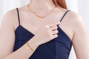 Detail view of the vintage queen coin pendant on a double-layer golden chain for women