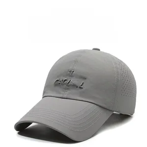 Detail of grey baseball cap featuring laser-cut ventilation holes and CASUAL embroidery