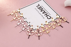 Macro detail of geometric hexagon drop earrings with long bar in gold, silver and rose gold