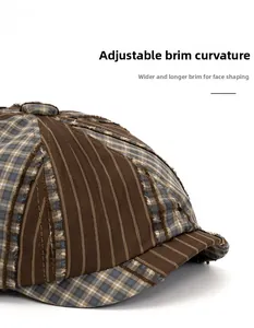 Detail of adjustable curved brim on vintage newsboy cap with patchwork fabric texture