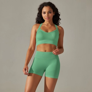 Front view of seamless grass green yoga set featuring racerback sports bra and high waist shorts