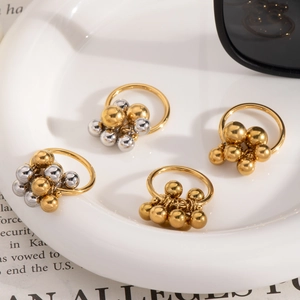 Detailed view of French vintage beaded rings in gold and silver on a white ceramic plate