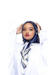 Detail of navy blue satin floral headscarf worn by model on white background