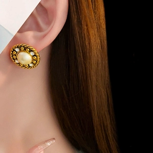Vue détaillée d'une boucle d'oreille vintage en perle ronde avec diamants sur modèle