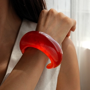 Close-up of translucent red resin wide cuff bracelet with a smooth glossy finish