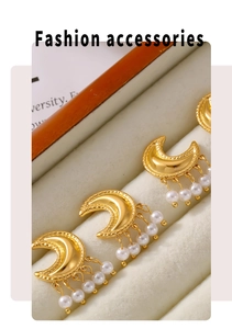 Detailed view of luxury gold moon earrings with hanging faux pearls on velvet