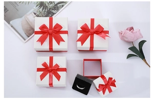 Square jewelry gift box with white lid, red base, and a matching red satin bow detail